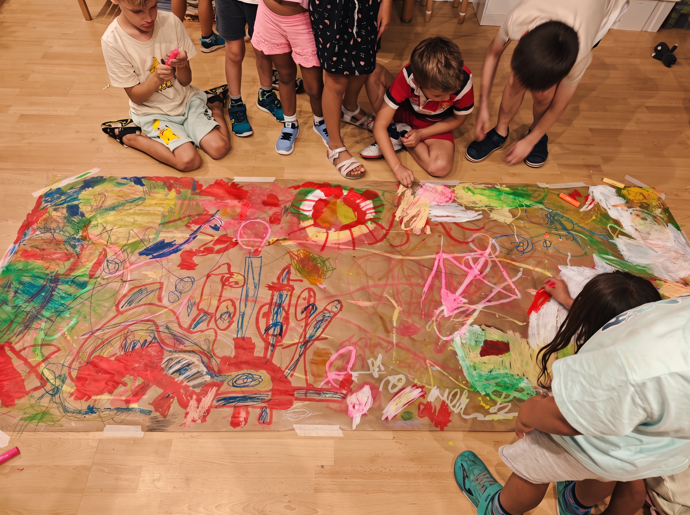 Manos de niños pintando con pigmentos naturales sobre papel